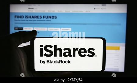 Stuttgart, Deutschland, 16.07.2024: Person, die ein Mobiltelefon mit dem Logo der US-amerikanischen ETF-Firma iShares (BlackRock Inc.) vor der Webseite hält. Fokus auf p Stockfoto