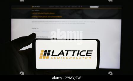 Stuttgart, Deutschland, 13.06.2024: Person, die ein Mobiltelefon mit dem Logo der US-amerikanischen Firma Lattice Semiconductor Corporation vor der Webseite hält. Fokus Stockfoto