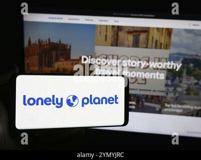 Stuttgart, Deutschland, 06.03.2024: Person mit Smartphone mit Logo der Reiseleitung Lonely Planet vor der Website. Konzentrieren Sie sich auf die Telefondiskretion Stockfoto