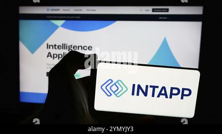 Stuttgart, Deutschland, 26.06.2024: Person mit Smartphone und Logo des US-Softwareunternehmens Integration Appliance Inc. (Intapp) vor der Website. Fo Stockfoto