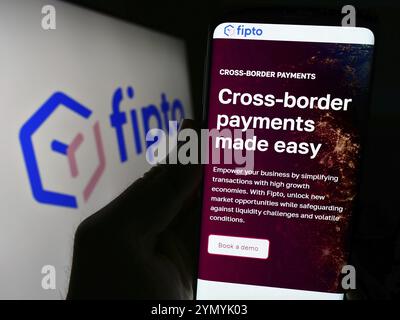 Stuttgart, Deutschland, 24.02.2024: Person, die ein Mobiltelefon hält und die Webseite des französischen Zahlungsunternehmens Fipto France SAS vor dem Firmenlogo trägt. Konzentrieren Sie sich auf Stockfoto