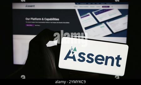 Stuttgart, Deutschland, 05-08-2024: Person, die ein Mobiltelefon mit dem Logo des kanadischen Supply-Chain-Unternehmens zustiment Compliance Inc. Vor der Webseite hält. Fo Stockfoto