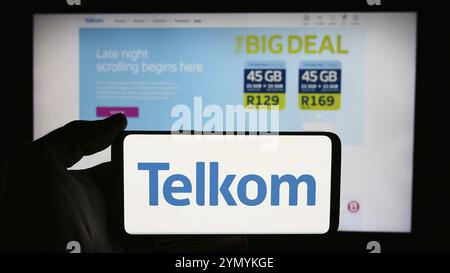 Stuttgart, Deutschland, 06.11.2024: Person, die ein Mobiltelefon mit dem Logo der südafrikanischen Firma Telkom SA SOC Limited vor der Webseite der Firma hält. Fo Stockfoto