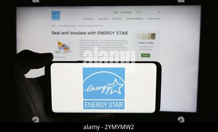 Stuttgart, Deutschland, 07.01.2024: Person mit Mobiltelefon mit Logo des US-Energieeffizienzprogramms Energy Star vor der Webseite. Konzentrieren Sie sich auf die Telefondiskretion Stockfoto