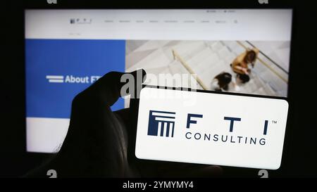 Stuttgart, Deutschland, 07.06.2024: Person mit Smartphone mit Logo des US-amerikanischen Unternehmensberatungsunternehmens FTI Consulting Inc. Vor der Website. Fokus Stockfoto