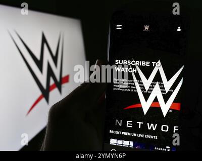 Stuttgart, Deutschland, 03.07.2024: Person, die ein Handy hält, mit Webseite der Promotionsfirma World Wrestling Entertainment (WWE) vor dem Logo. Fokus Stockfoto