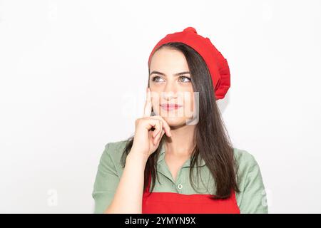 Porträt einer jungen Küchenchefin mit roter Schürze isolierter weißer Farbe Stockfoto