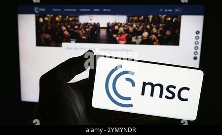 Stuttgart, Deutschland, 03.06.2024: Person mit Smartphone mit Logo der jährlichen Münchner Sicherheitskonferenz (MSC) vor der Website. Konzentrieren Sie sich auf Pho Stockfoto