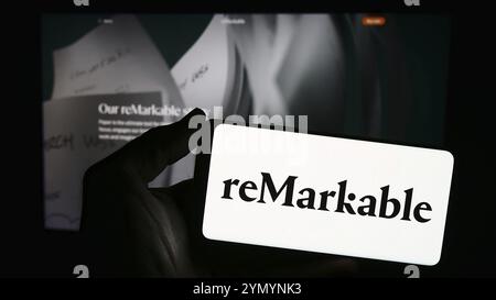 Stuttgart, Deutschland, 28.03.2024: Person mit Smartphone mit Logo des norwegischen E-Reader-Unternehmens bemerkenswert WIE vor der Website. Konzentrieren Sie sich auf Telefondistanz Stockfoto