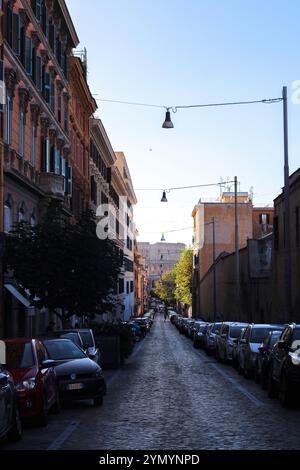 Kolosseum von einer Stadtstraße. Blick auf das Kolosseum von einer kopfsteingepflasterten Straße in Rom, Italien. Malerische Stadtlandschaft mit historischem Charme. Stockfoto