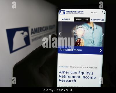 Stuttgart, Deutschland, 07-01-2024: Person, die ein Mobiltelefon hält, mit Website der American Equity Investment Life Holding Company vor dem Logo. Fokus auf ce Stockfoto