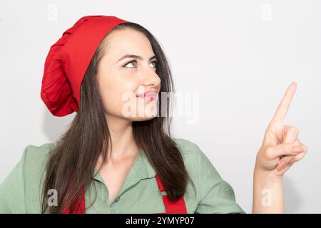 Porträt einer jungen Küchenchefin mit roter Schürze isolierter weißer Farbe Stockfoto
