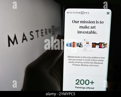 Stuttgart, Deutschland, 16.05.2024: Person, die ein Mobiltelefon hält, mit Webseite der US-amerikanischen Kunstinvestitionsgesellschaft Masterworks LLC vor dem Logo. Fokus auf Mitte o Stockfoto