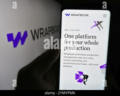Stuttgart, Deutschland, 14.05.2024: Person, die ein Mobiltelefon hält, mit Webseite des US-Softwareunternehmens TakeOne Network Corp. (Wrapbook) vor dem Logo. Fokus Stockfoto