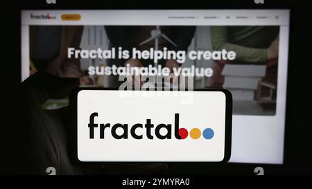 Stuttgart, Deutschland, 05-08-2024: Person mit Handy mit Logo des Künstlichen Intelligenz-Unternehmens Fractal Analytics Pvt. Ltd. Vor der Webseite. Stockfoto