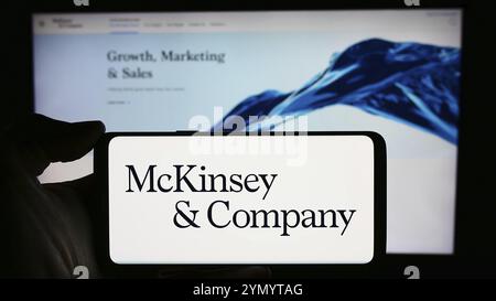 Stuttgart, Deutschland, 16.03.2024: Person, die ein Mobiltelefon mit dem Logo des US-amerikanischen Beratungsunternehmens McKinsey and Company vor der Webseite hält. Konzentrieren Sie sich auf das Telefon Stockfoto