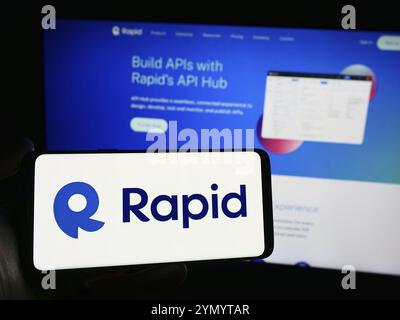 Stuttgart, Deutschland, 28.03.2024: Person mit Mobiltelefon mit Logo der amerikanischen API-Hub-Firma R Software Inc. (RapidAPI) vor der Webseite. Foc Stockfoto