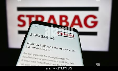 Stuttgart, 15.04.2024: Mobiltelefon mit Logo des österreichischen Bauunternehmens Strabag SE vor der Business-Website. Fokus oben links von Stockfoto