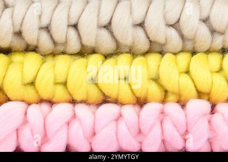 Nahaufnahme von Wolldecken in weichem Pink, Beige und Gelb – gemütliche handgefertigte Texturen für Wohnkultur, Strickprojekte und warme Innenräume Stockfoto