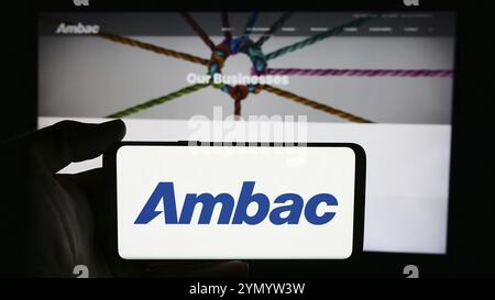 Stuttgart, Deutschland, 07.03.2024: Person, die ein Mobiltelefon mit dem Logo der amerikanischen Finanzgesellschaft Ambac Financial Group Inc. Vor der Business-Website hält Stockfoto
