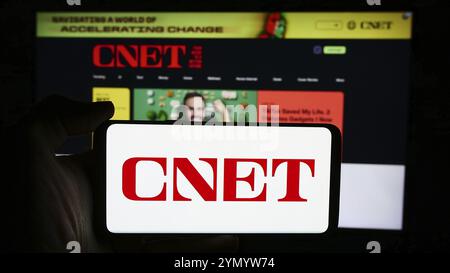 Stuttgart, Deutschland, 06.03.2024: Person, die ein Mobiltelefon mit Logo des US-amerikanischen Medienplattformunternehmens CNET vor der Business-Website hält. Konzentrieren Sie sich auf Stockfoto