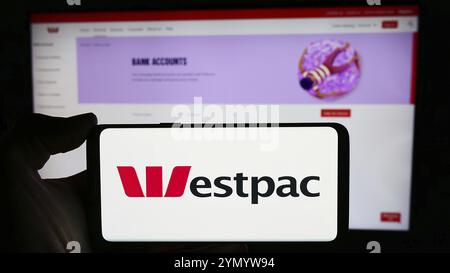 Stuttgart, Deutschland, 16.03.2024: Person, die ein Mobiltelefon mit dem Logo des australischen Finanzunternehmens Westpac Banking Corporation vor der Webseite hält. Fo Stockfoto