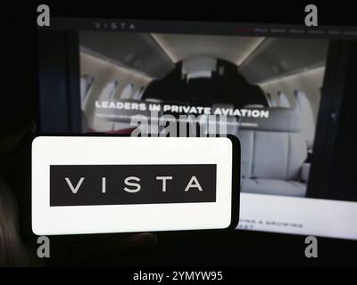 Stuttgart, Deutschland, 07.11.2024: Person, die ein Smartphone mit dem Logo des Emirat-Luftfahrtunternehmens Vista Global Holding Limited vor der Website hält. Fokussieren Stockfoto