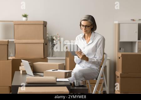 Positive Geschäftsfrau mittleren Alters mit Tablet-Computer Stockfoto