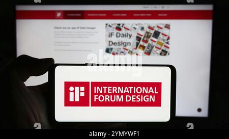 Stuttgart, Deutschland, 14.03.2024: Person mit Handy mit Logo der deutschen Organisation International Forum Design (IF) vor der Business-Website Stockfoto