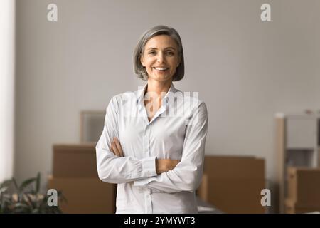 Glückliche, selbstbewusste grauhaarige Geschäftsfrau posiert für Porträt Stockfoto