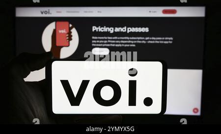 Stuttgart, Deutschland, 14.05.2024: Person mit Mobiltelefon mit Logo des schwedischen Elektroroller-Unternehmens VOI Technology ab vor Business Web p Stockfoto