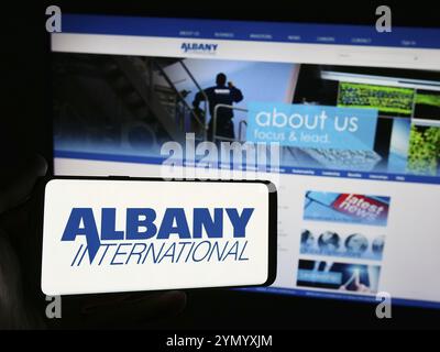 Stuttgart, Deutschland, 07.03.2024: Person mit Smartphone mit Logo des US-amerikanischen Industriegüterunternehmens Albany International Corp. Vor der Website. Foc Stockfoto