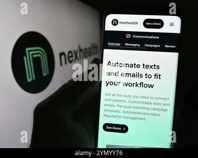 Stuttgart, Deutschland, 28.03.2024: Person, die ein Smartphone hält, mit der Webseite des US-amerikanischen Gesundheitssoftware-Unternehmens NexHealth Inc. Vor dem Logo. Schwerpunkt auf cen Stockfoto