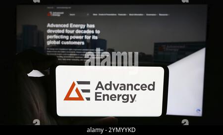 Stuttgart, Deutschland, 07.03.2024: Person, die ein Mobiltelefon mit Logo des US-amerikanischen Technologieunternehmens Advanced Energy Industries Inc. Vor der Business-Webpa hält Stockfoto