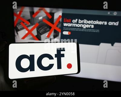 Stuttgart, Deutschland, 03.07.2024: Person mit Handy mit Logo der russischen Organisation Anti-Corruption Foundation (ACF) vor der Webseite. Fokus Stockfoto