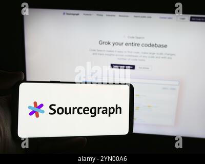 Stuttgart, Deutschland, 07.11.2024: Person, die ein Smartphone mit dem Logo des US-amerikanischen Code Intelligence-Unternehmens Sourcegraph Inc. Vor der Website hält. Konzentrieren Sie sich auf Pho Stockfoto