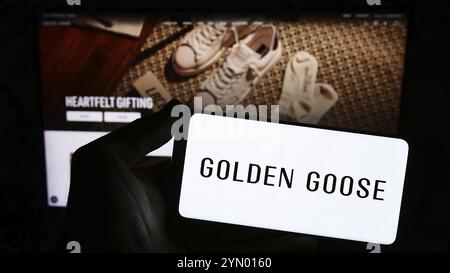 Stuttgart, Deutschland, 03.05.2024: Person mit Smartphone mit Logo der italienischen Sneaker-Firma Golden Goose S.p.A. vor der Website. Konzentrieren Sie sich auf das Telefon Stockfoto