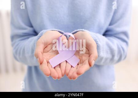 Frau mit violettem Band auf hellem Hintergrund, Nahaufnahme. Alzheimer-Krankheit, Epilepsie und Pankreaskarzinom-Bewusstsein Stockfoto