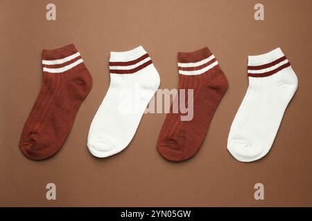 Verschiedene weiche Socken auf hellbraunem Hintergrund, flach geschnitten Stockfoto