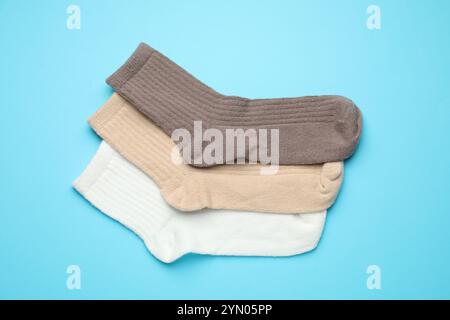 Verschiedene weiche Socken auf hellblauem Hintergrund, flach geschnitten Stockfoto