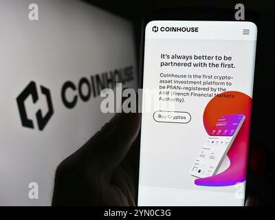 Stuttgart, Deutschland, 14.03.2024: Person, die ein Handy hält, mit Webseite der französischen Krypto-Investmentgesellschaft Coinhouse SAS vor dem Logo. Schwerpunkt auf cen Stockfoto