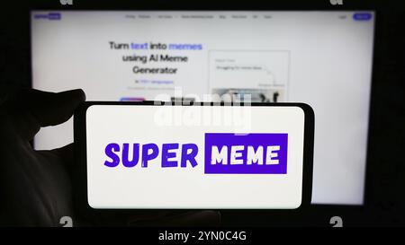 Stuttgart, Deutschland, 03-08-2024: Person, die ein Mobiltelefon mit dem Logo des MEME-Generationsunternehmens Supermeme.ai Inc. Vor der Business-Webseite hält. Konzentrieren Sie sich auf Stockfoto