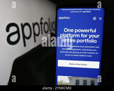 Stuttgart, Deutschland, 28.04.2024: Person, die ein Mobiltelefon hält, mit Webseite des US-amerikanischen Immobiliensoftwareunternehmens AppFolio Inc. Vor dem Logo. Konzentrieren Sie sich auf Cent Stockfoto