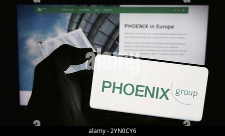 Stuttgart, Deutschland, 03.01.2024: Person mit Smartphone mit Logo des deutschen Pharmagroßhandels PHOENIX Pharmahandel vor der Website. Fokus Stockfoto