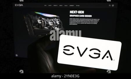 Stuttgart, 24.02.2024: Person, die ein Smartphone mit Logo des US-amerikanischen Computerhardware-Unternehmens EVGA Corporation vor der Website hält. Konzentrieren Sie sich auf Pho Stockfoto