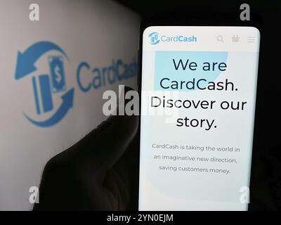 Stuttgart, Deutschland, 29.04.2024: Person, die ein Mobiltelefon hält, mit Webseite des US-amerikanischen Geschenkkartenmarktplatzes CardCash vor dem Firmenlogo. Konzentrieren Sie sich auf Stockfoto