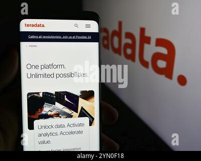 Stuttgart, Deutschland, 07.05.2024: Person, die ein Mobiltelefon hält, mit Webseite des US-amerikanischen Datenbanksoftware-Unternehmens Teradata Corporation vor dem Logo. Konzentrieren Sie sich auf Stockfoto