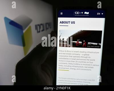 Stuttgart, 10.07.2024: Person, die ein Handy hält, mit Webseite des israelischen Entwicklungsunternehmens Shikun und Binui vor dem Logo. Konzentrieren Sie sich auf die Mitte Stockfoto