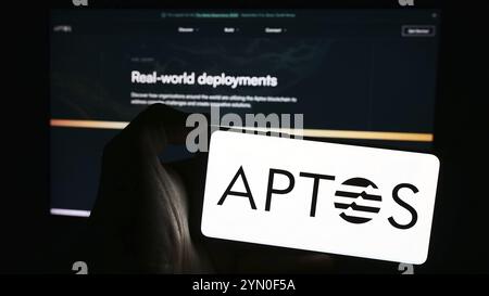 Stuttgart, 28.03.2024: Person, die ein Mobiltelefon mit dem Logo der Protokollentwicklungsorganisation Aptos Foundation vor der Webseite hält. Fokussieren Stockfoto