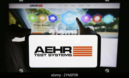 Stuttgart, Deutschland, 28.04.2024: Person, die ein Mobiltelefon mit Logo des US-amerikanischen Halbleiterprüfers Aehr Test Systems vor der Business-Website hält. Stockfoto